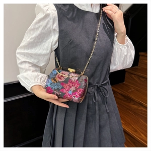 Detailansicht der bunten Pailletten-Abendtasche mit Bambusgriff und goldener Kette