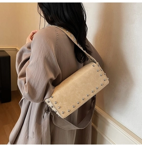 Detail view of beige shoulder bag with silver rivet accents and soft PU leather texture