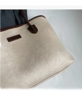 Detail shot of vintage cream tote bag showing soft textured faux leather and edge paint