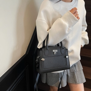 Minimalist black lychee pattern handbag with silver clasp shown on model