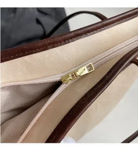Macro detail of golden metal zipper and herringbone fabric lining on the beige tote bag