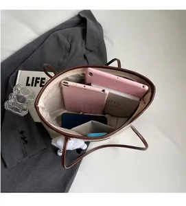 Top view showing spacious interior of off-white canvas tote with brown leather handles