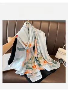 Detail of light blue floral silk shawl with satin finish and elegant flower pattern