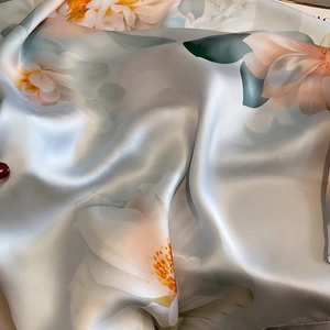 Elegant floral print silk scarf with peach peonies on a lustrous light blue satin fabric