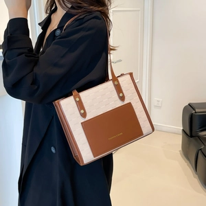 Minimalist woven tote bag with brown leather trim shown in a modern interior setting