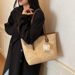Borsa tote minimalista in pelle scamosciata beige con manici in pelle marrone e charm