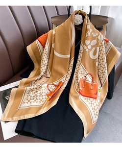 Detailed pattern of silk scarf featuring horse bits and equestrian bag motifs