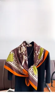 Detail of elegant printed square silk scarf featuring luxury bag patterns and orange borders