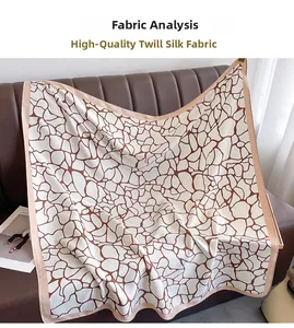 Close-up of premium twill silk scarf with brown geometric print on leather texture