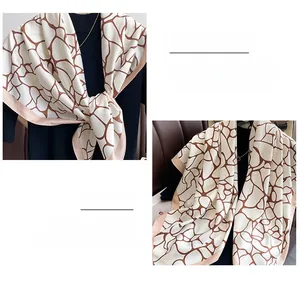 Detailed view of twill silk scarf showing geometric print and fine edge stitching detail