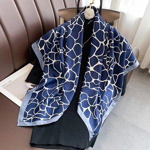 Detail of navy silk twill scarf with white geometric giraffe pattern on black outfit