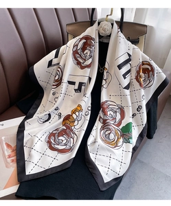 Detailed close-up of large floral silk scarf with vintage roses and geometric patterns