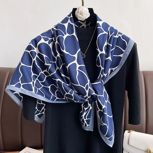 Blue and white silk-feel geometric print square scarf styled on a black turtleneck outfit