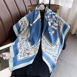 Detailed shot of blue and white silk scarf with luxury bag and houndstooth patterns