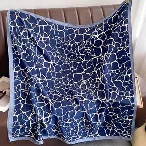 Detailed close-up of premium twill square scarf with blue and white geometric stone pattern