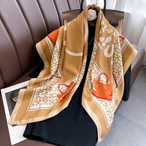 Elegant silk scarf with geometric patterns and handbag prints in caramel and orange