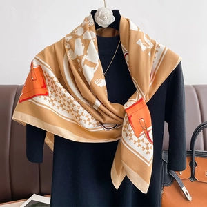 Detail of silk scarf with orange bag patterns and white geometric motifs over black outfit