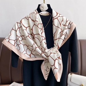 Close-up of geometric pattern silk scarf with marble print and pink border detail