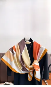 Detail of color-block silk scarf in twill fabric draped on a display mannequin