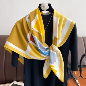 Close-up of yellow abstract print satin scarf tied elegantly with artistic block patterns