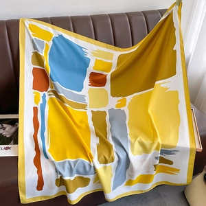 Detail of artistic satin silk scarf with abstract geometric patterns and yellow hem edge