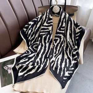 Elegant zebra print silk-touch large square scarf styled on a beige knitted dress