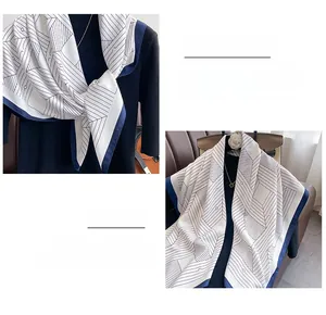 Detailed view of lightweight silk scarf featuring geometric lines and blue borders