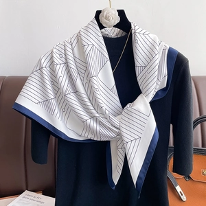 Elegant geometric line print silk scarf tied on a mannequin with blue and white contrast