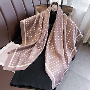 Detailed view of dusty pink silk scarf with white polka dots and border design