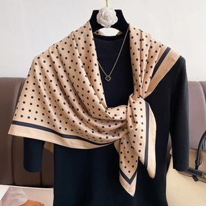 Detailed view of apricot silk scarf with black polka dots and contrasting borders