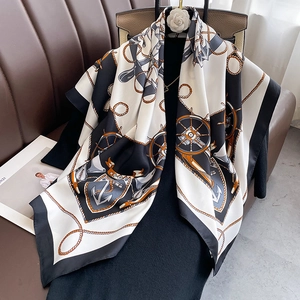 Detail of nautical print silk scarf featuring anchors and ropes on a black garment