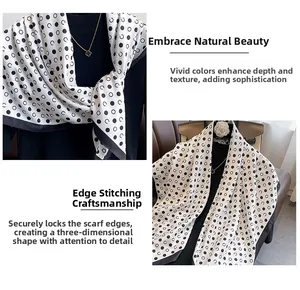 Detailed view of the refined edge stitching on a black and white polka dot silk scarf