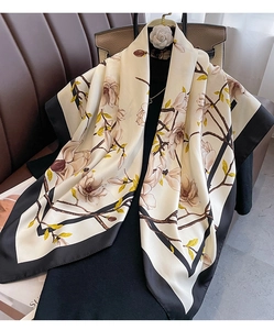 Close-up of vintage floral silk scarf with magnolia prints on an elegant black dress