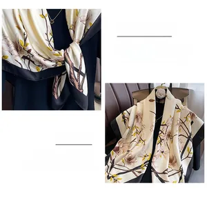 Close-up of elegant magnolia print silk scarf with fine stitching and black contrast border