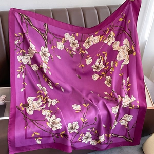 Detail of elegant dark purple silk scarf with white magnolia floral print and hemmed edges