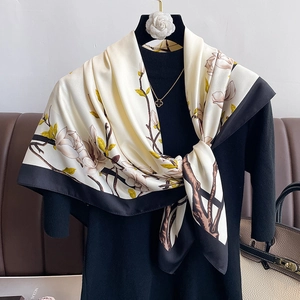Detailed close-up of vintage floral silk scarf with magnolia prints and black borders