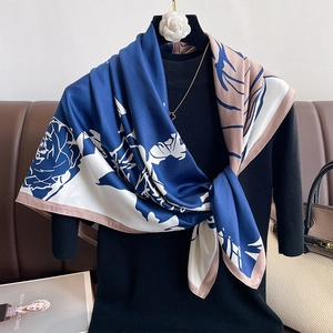 Detail of floral print silk scarf featuring elegant blue roses and satin texture