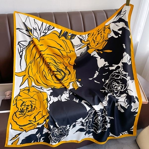 Detailed texture of silk-like floral shawl draped elegantly on a brown leather sofa