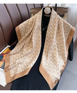 Détail du foulard carré en soie avec motif monogramme et bords en satin marron chic