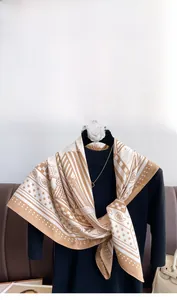 Vue détaillée d'un élégant foulard en soie beige avec motifs d'étoiles et paisley