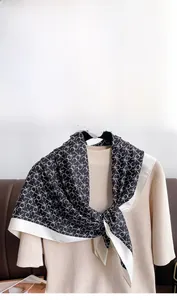 Détail d'un élégant carré en soie sergée noir et blanc avec motifs de logo de luxe
