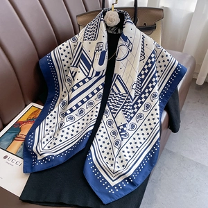 Carré de soie bleu et blanc aux motifs paisley et étoiles dans un décor luxueux