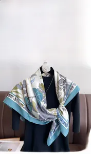 Detail view of the soft silk-like twill scarf featuring elegant floral patterns and drape