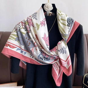 Detail of floral and leopard print silk scarf draped elegantly on a mannequin