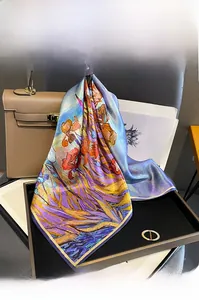 Vue détaillée d'un foulard en soie à imprimé iris drapé sur un sac à main en cuir chic
