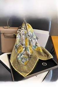 Detail of floral mulberry silk scarf elegantly tied to a classic brown handbag
