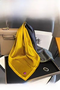Detailed texture of a striped mulberry silk scarf tied to a leather handbag handle