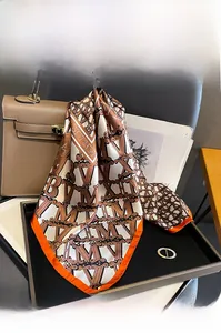 Detail of 100% mulberry silk square scarf with geometric letters and orange edges