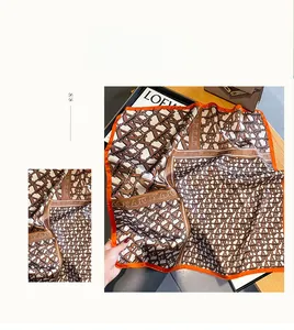 Detail of silk square scarf featuring vintage letter patterns and geometric chain motifs