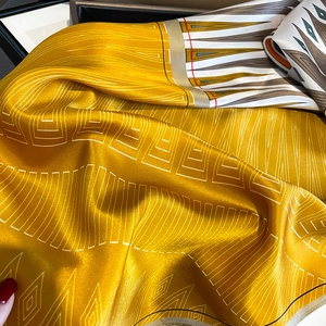 Luxurious yellow silk scarf with geometric gray patterns and smooth pearl luster finish